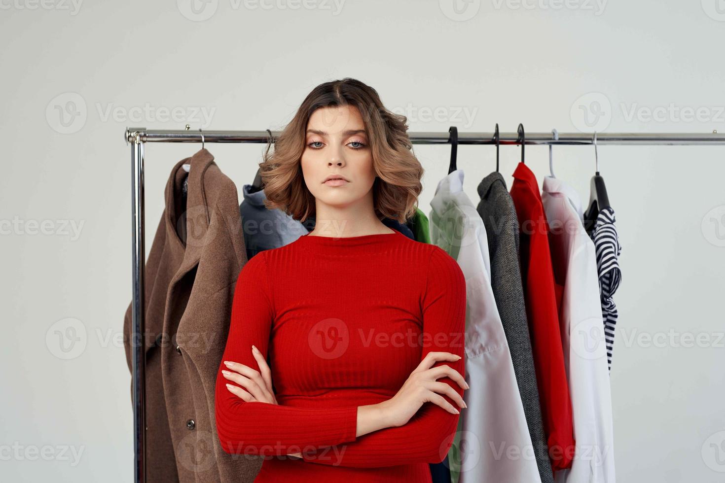cheerful woman in a red jacket near the wardrobe isolated background photo