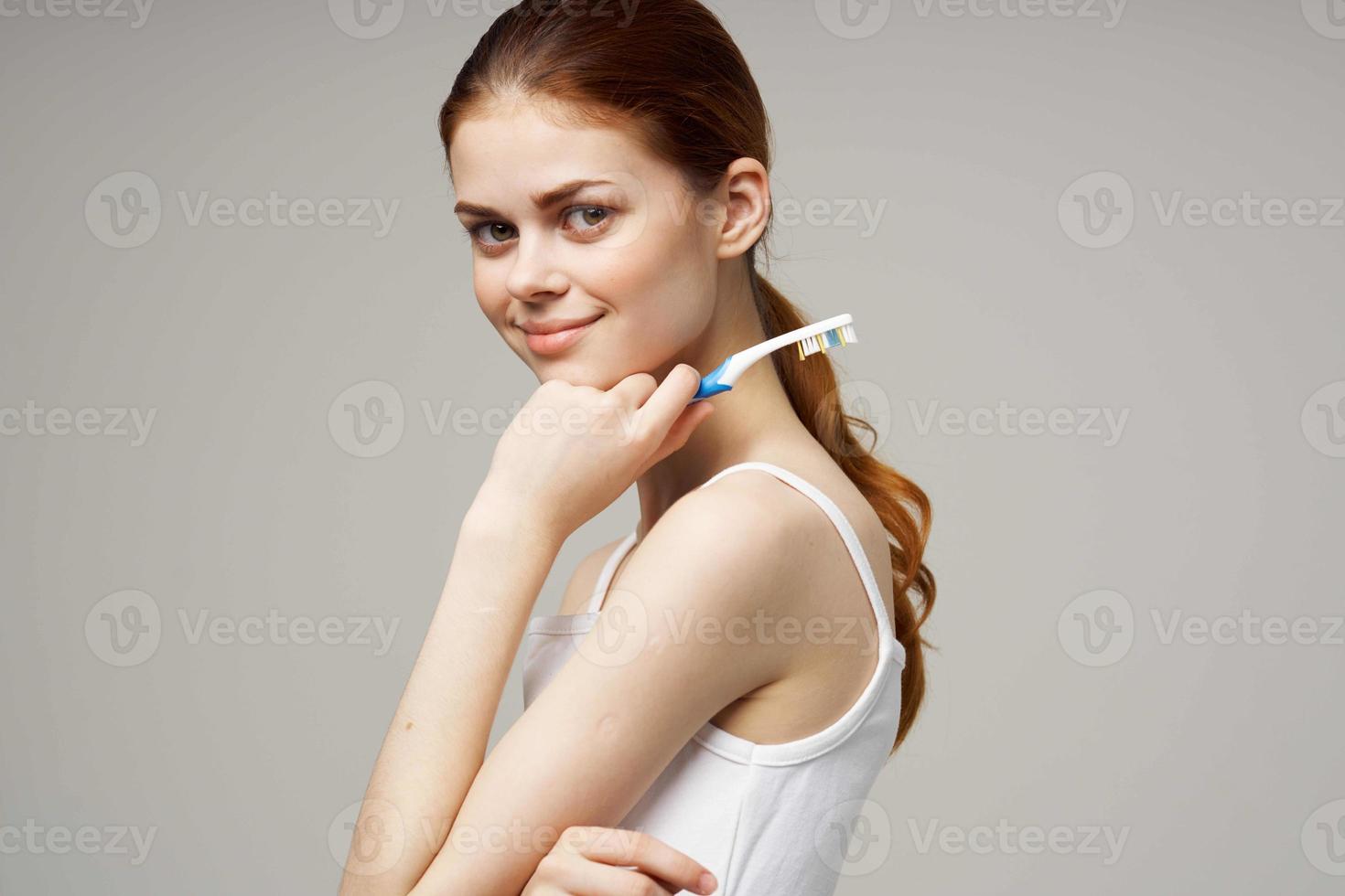 alegre mujer con un cepillo de dientes en mano Mañana higiene ligero antecedentes foto