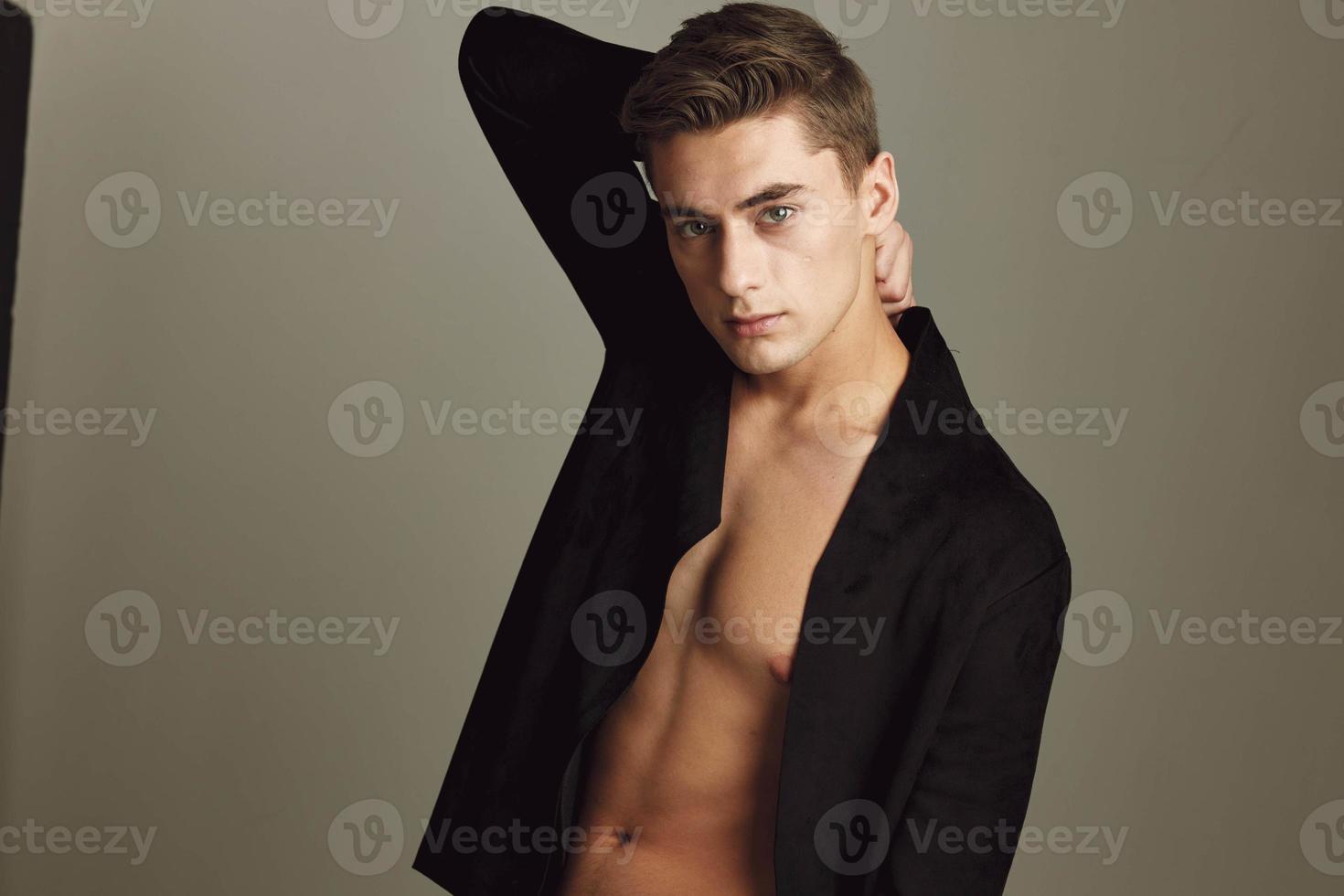 Man with black shirt unbuttoned hairstyle studio emotions beige background photo