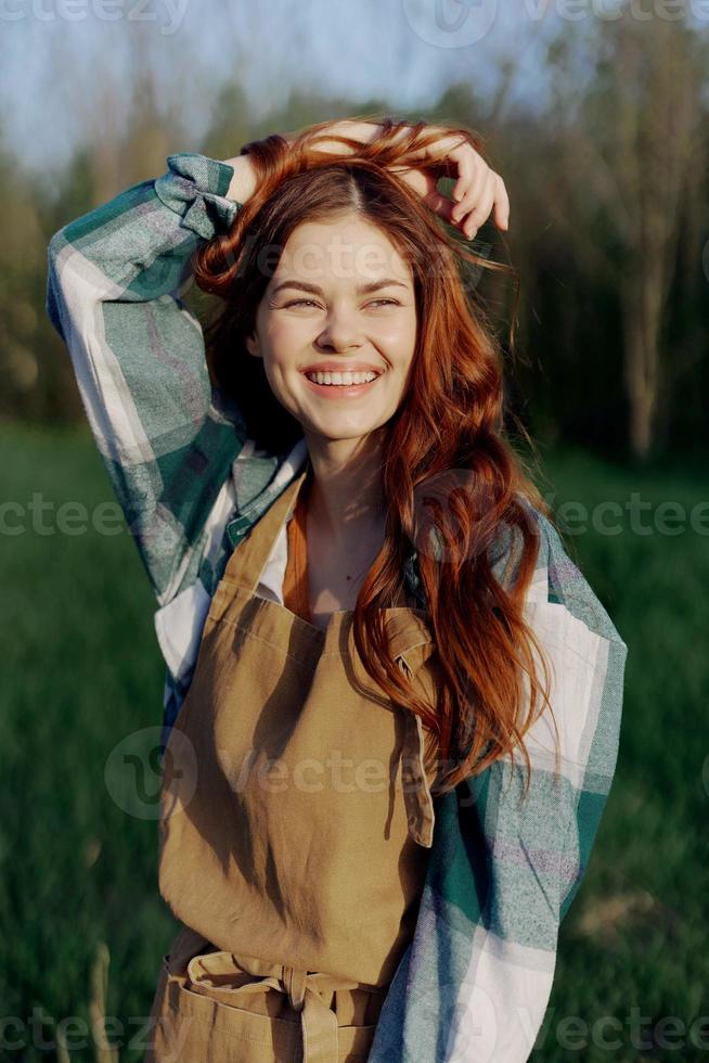 A young woman in work clothes and wearing an apron outdoors enjoying the sunset and relaxing after a hard day's work photo