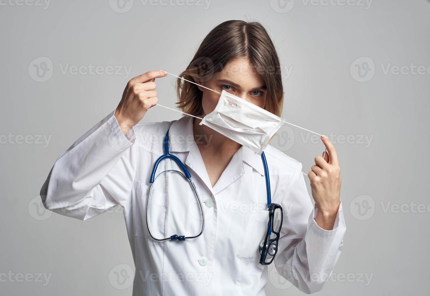 Professional doctor nurse in a gown with a stethoscope and a medical mask photo
