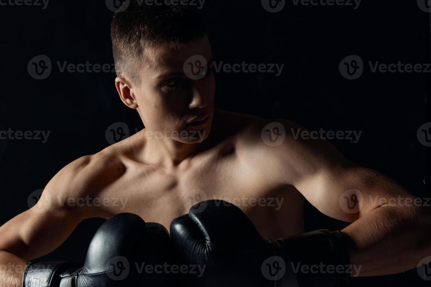 sport guy in boxing gloves close-up portrait black background cropped view photo