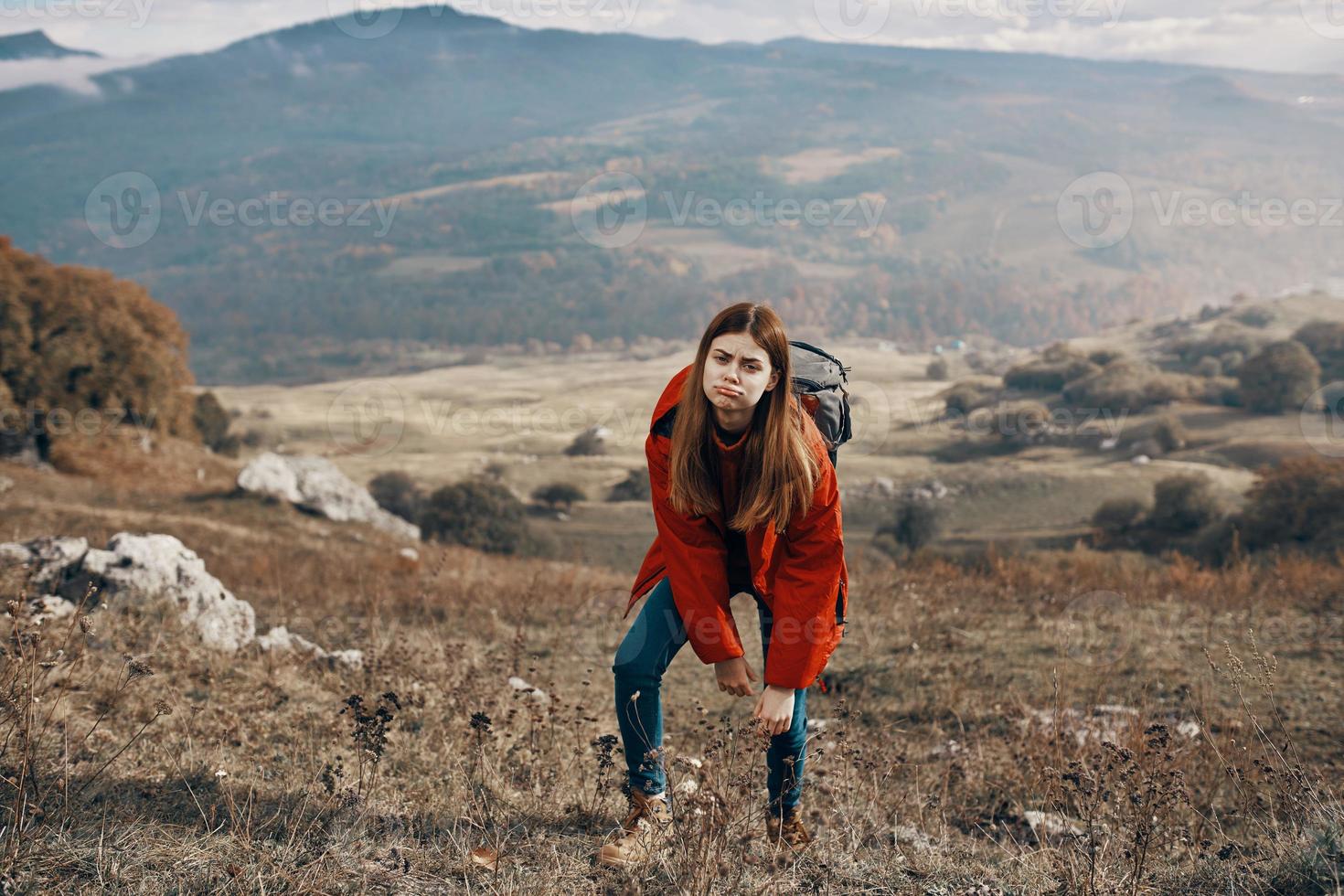 mujer caminante en chaqueta botas con mochila viaje en montañas paisaje foto