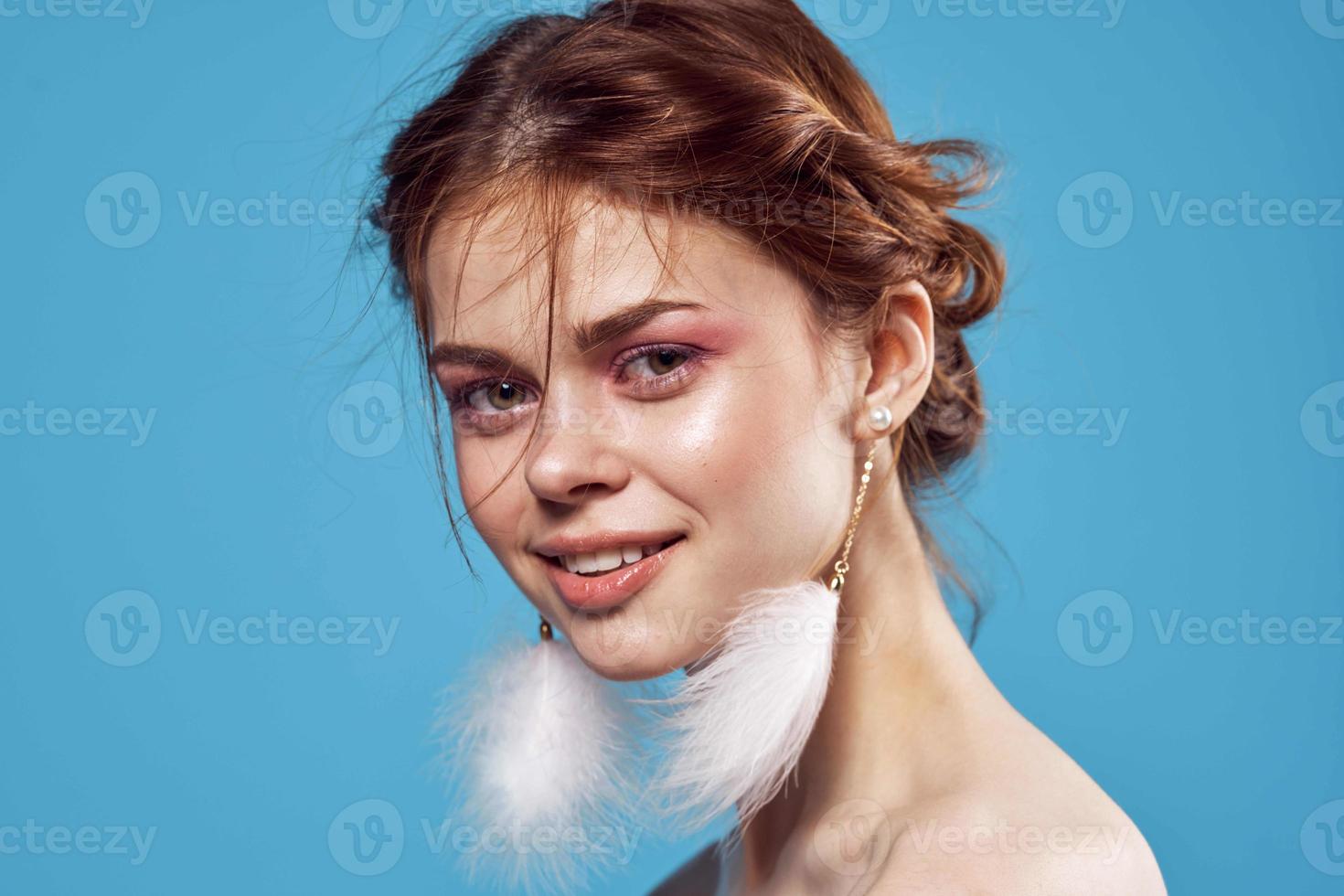 woman with bare shoulders bright makeup fluffy earrings model photo