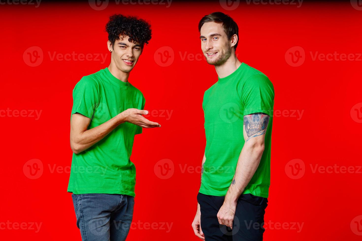 two friends in green t-shirts fun communication red background photo