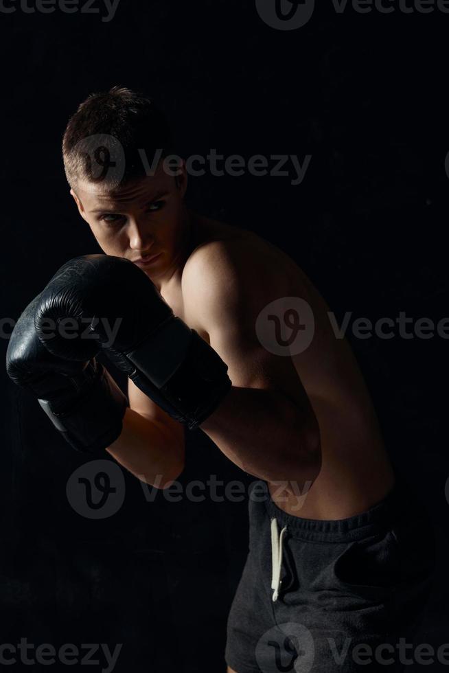 boxer in black gloves bent down on a dark background bodybuilder photo