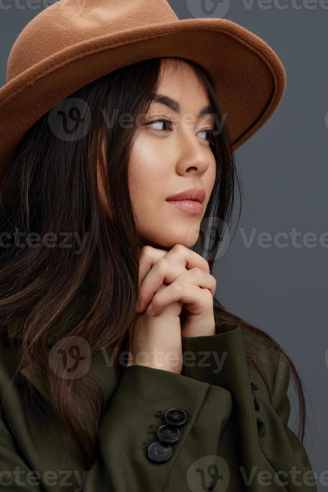 hermosa mujer en un traje con un sombrero posando casual vestir gris antecedentes foto