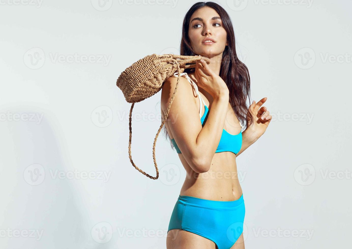 mujer en trajes de baño playa bolso bikini posando glamour viaje foto