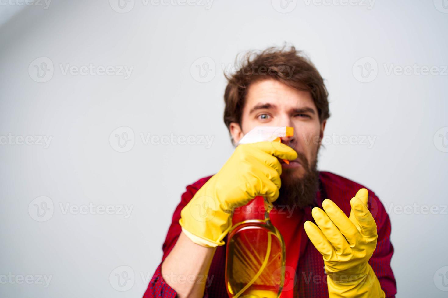 Man in yellow rubber gloves detergent housework rendering services close-up photo