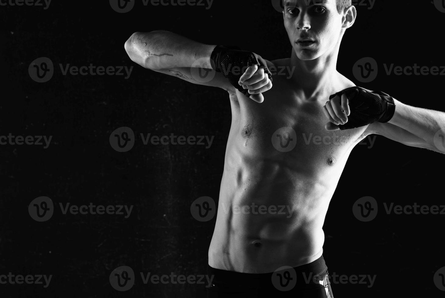 hombre con un mejorado torso rutina de ejercicio ejercicio deporte oscuro antecedentes foto