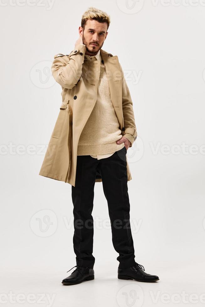 man in trendy hairstyles in a coat autumn style fashion in full growth photo