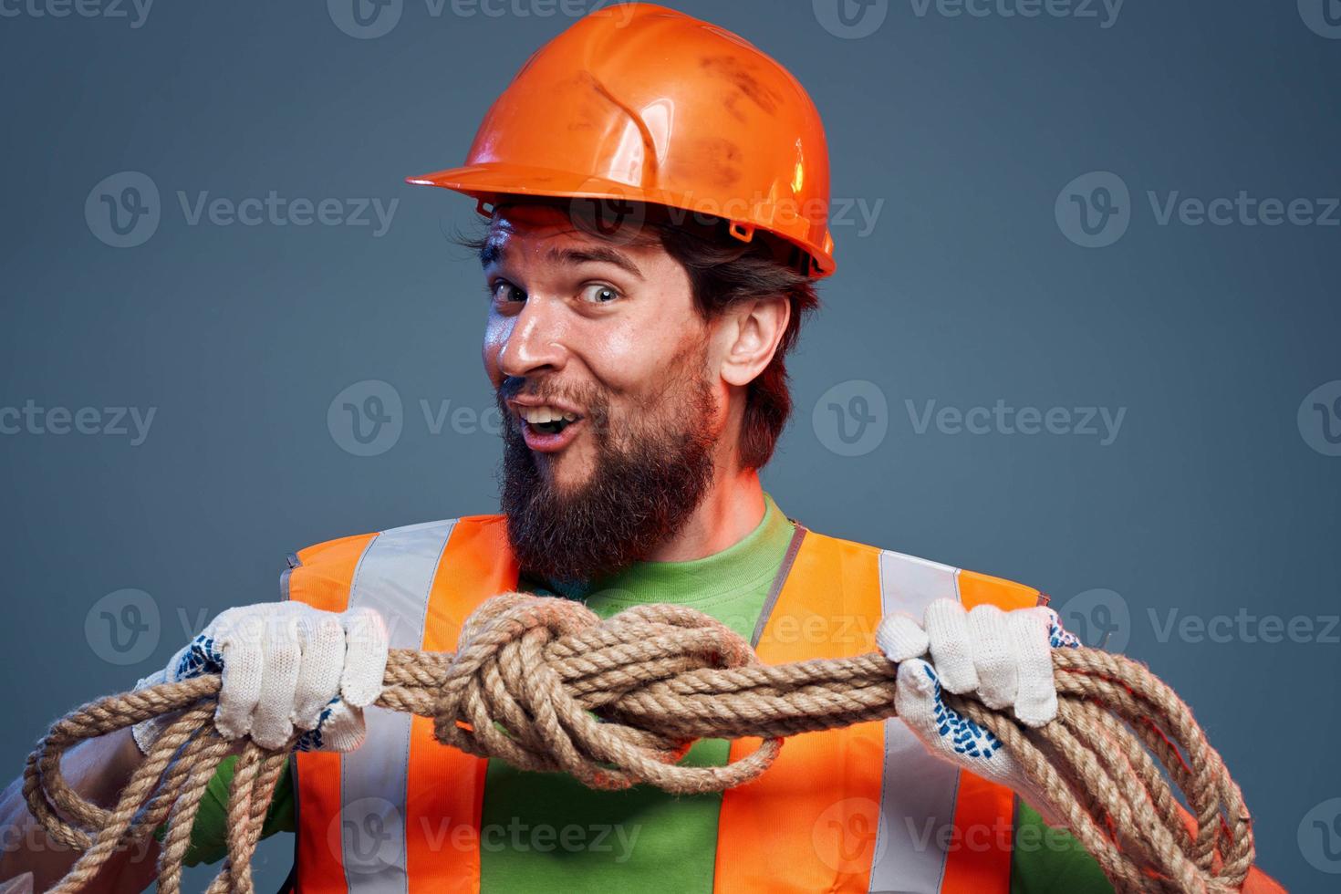 Emotional man in work uniform orange helmet rope professional photo