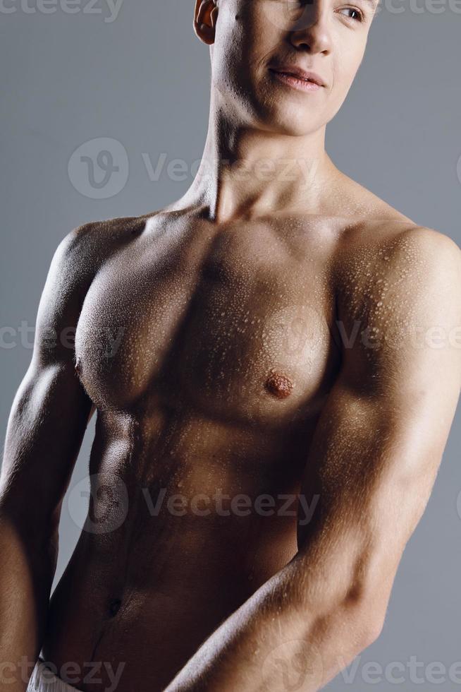 portrait of a bodybuilder with a pumped-up torso on a gray background closeup cropped view of a model photo