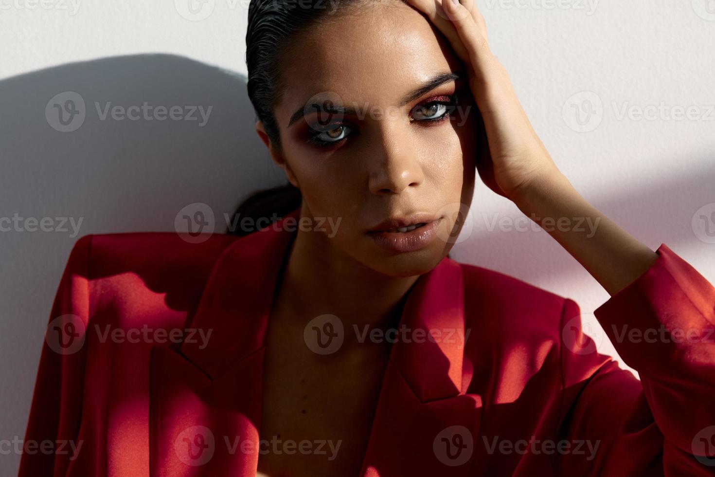 retrato de un sexy morena con noche maquillaje y un rojo chaqueta de cerca foto