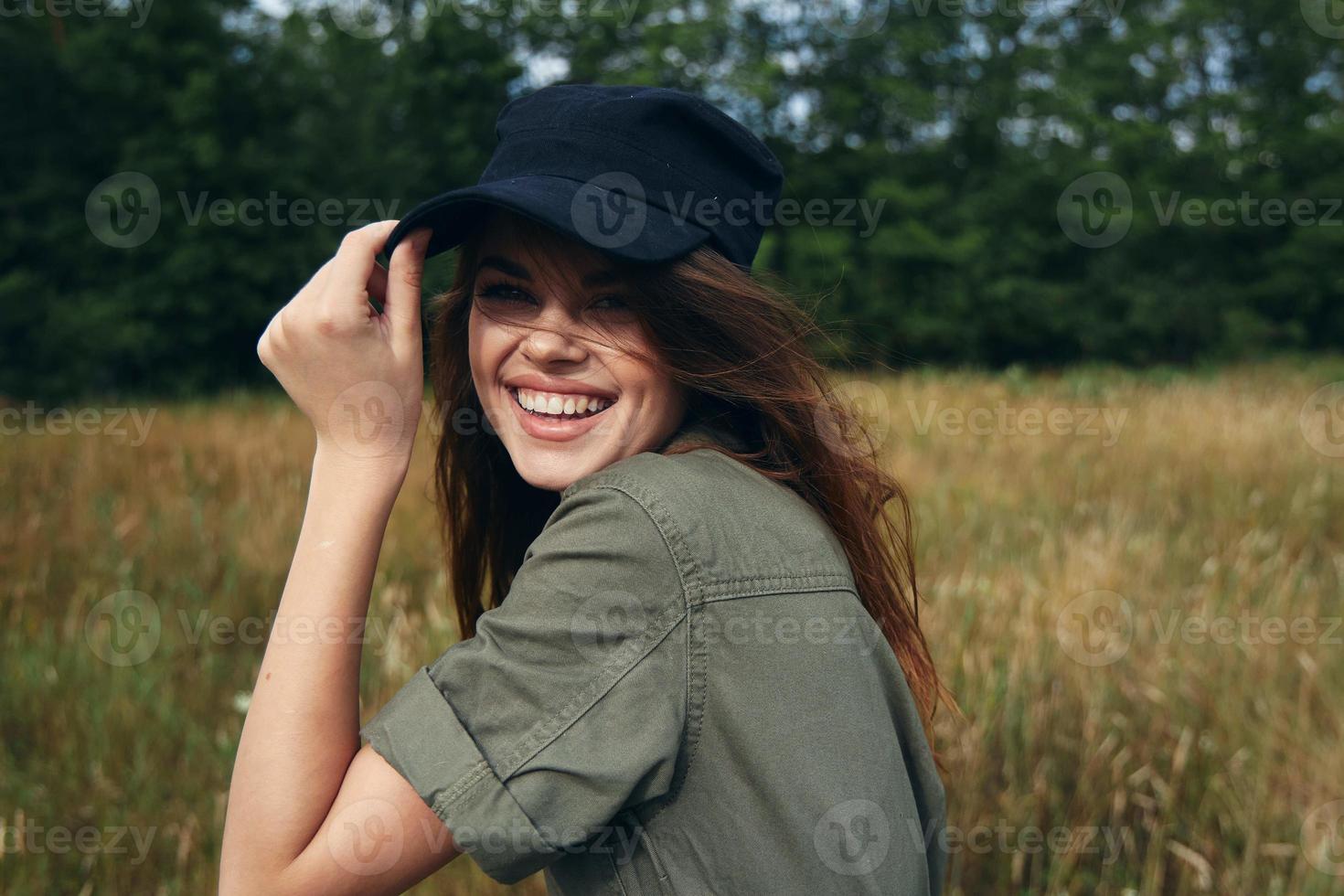 Happy woman in blue cap and green shirt laughs photo