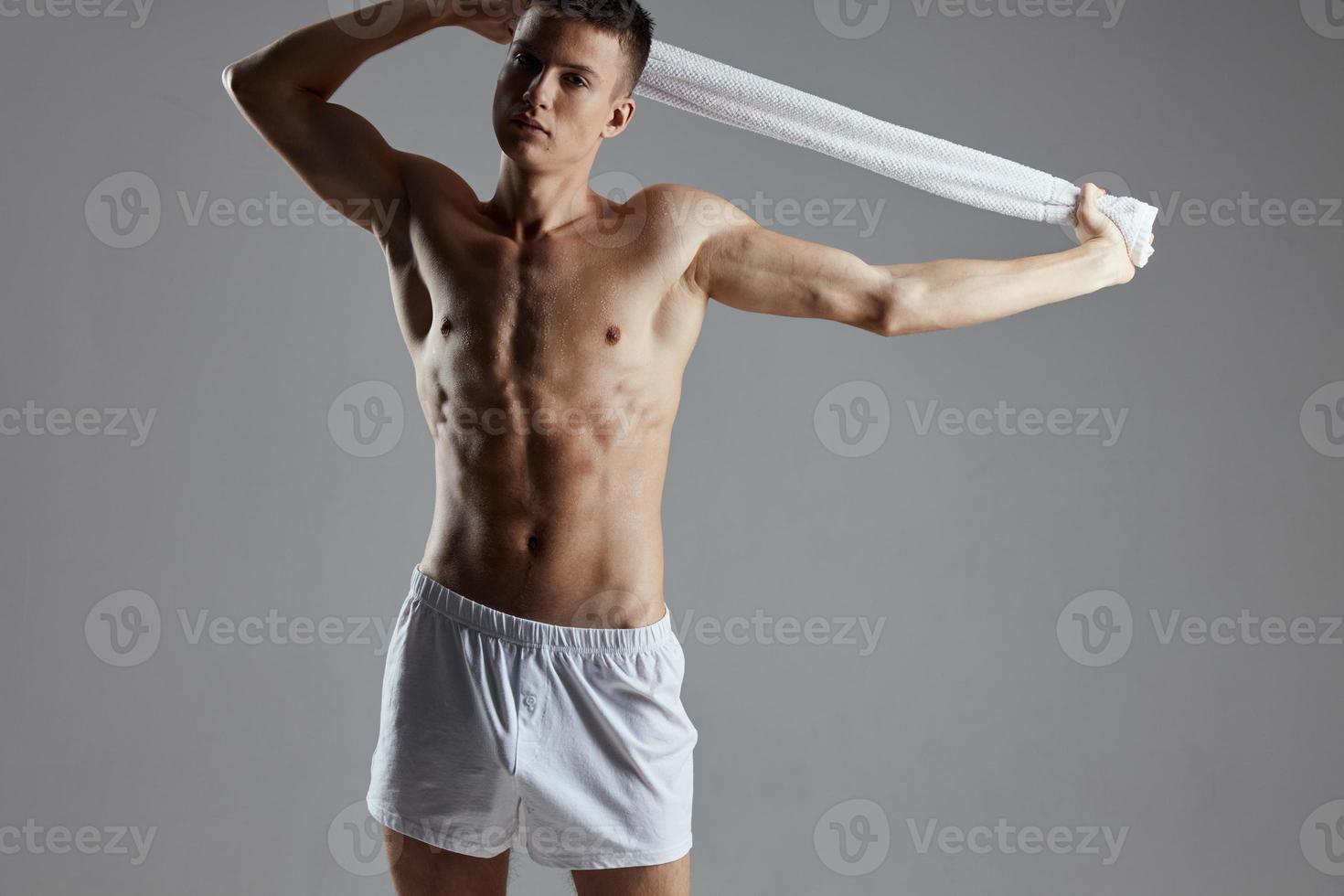 guy with a naked torso holding a towel in his hands white shorts workout motivation isolated background photo
