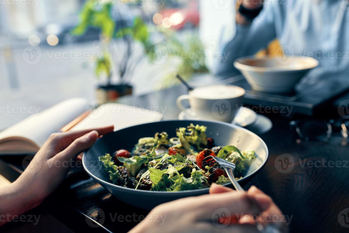 delicious food salad in a plate fork notepad with the inscription and woman in shirt cafe interior photo