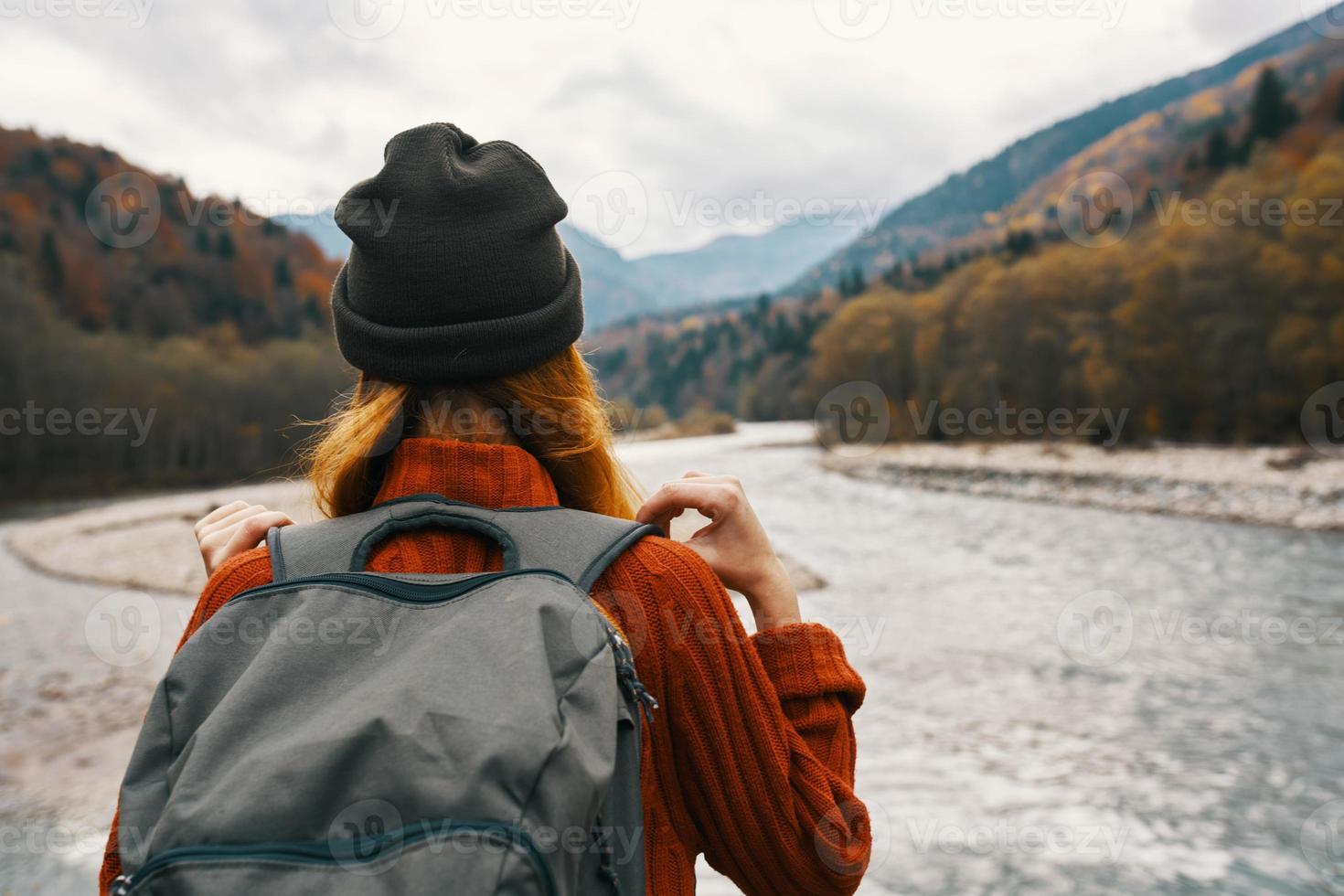 woman traveler on vacation in the mountains in nature near the river hold hands behind her head photo