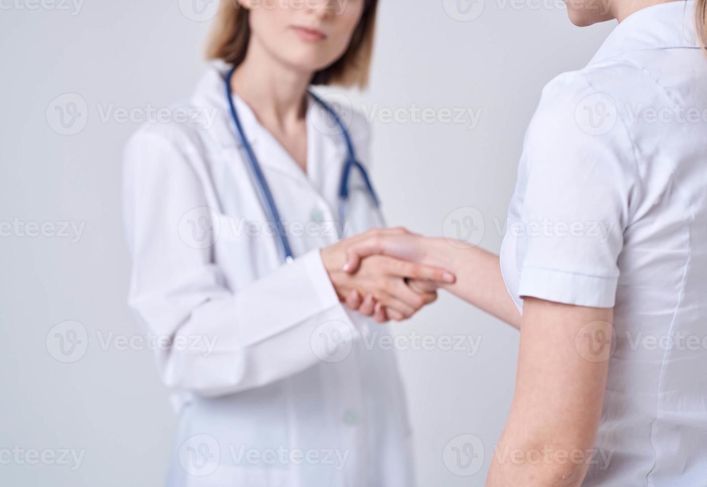 médico y paciente sacudir manos con cada otro en un ligero antecedentes recortado ver foto