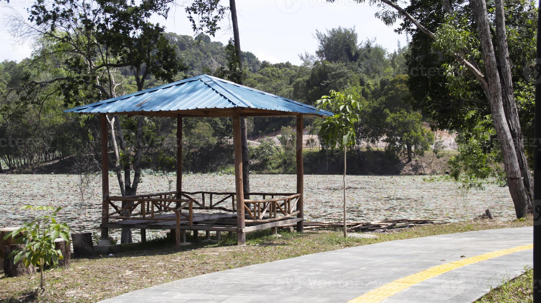 un Kiosko o un cazar un sitio para relajarse y sentar reunir cerca el lago lado y un ruta en un público parque. foto