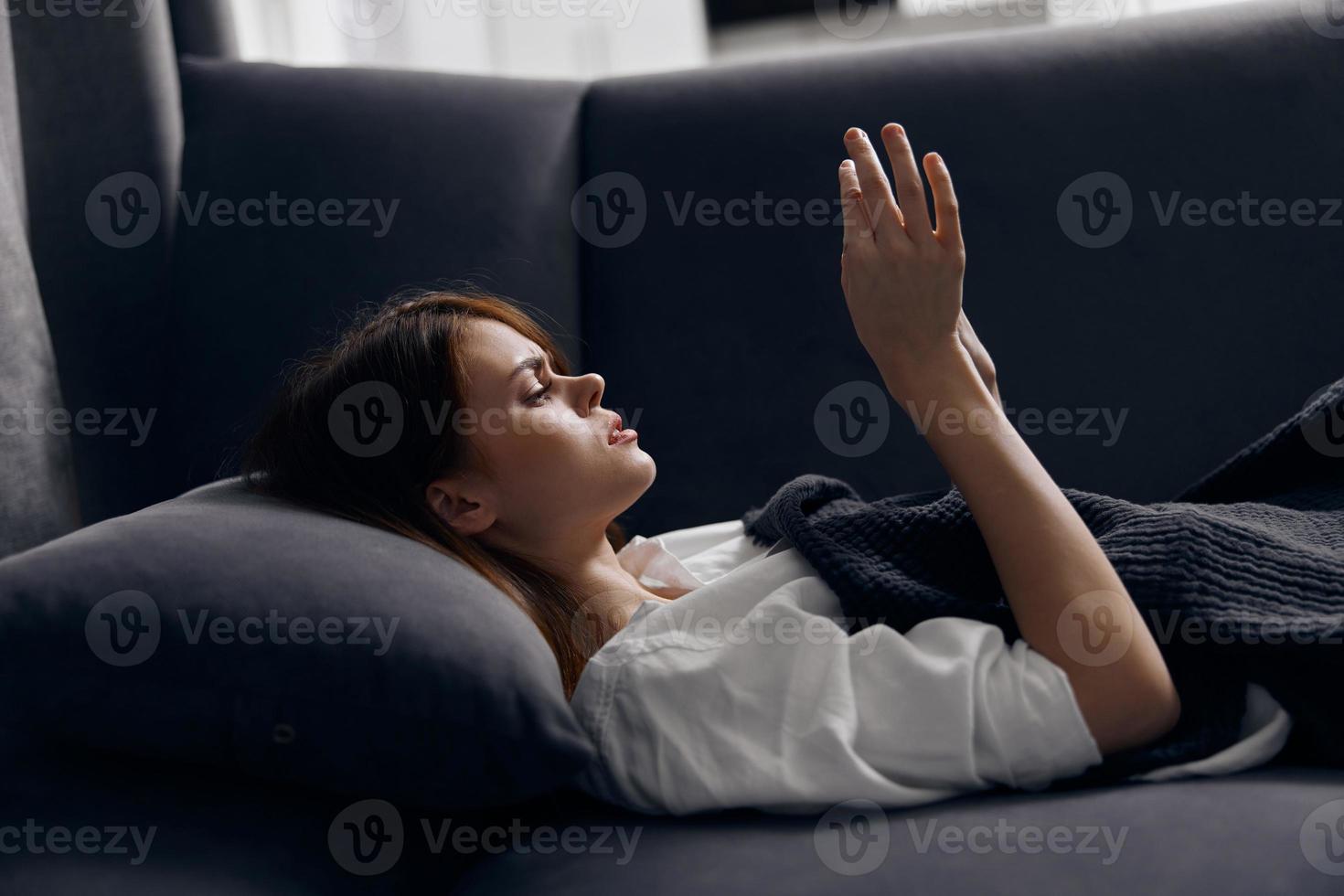 woman resting lying on the couch with a mobile phone in her hand and a