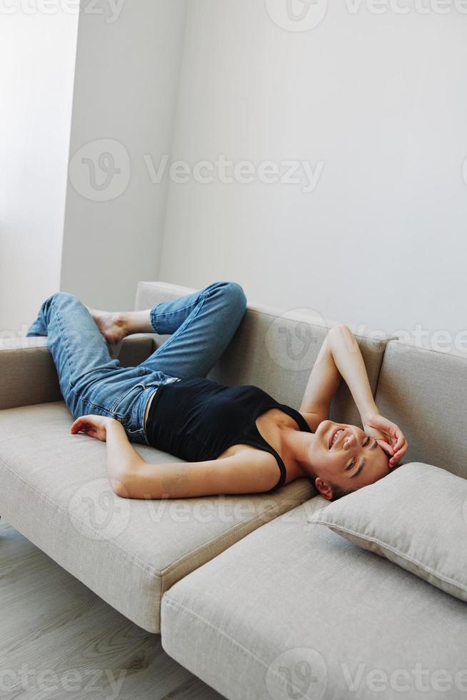 Young woman with short haircut hair having fun at home on the couch smile and happiness, vacation at home, natural posing without filters, free copy space photo
