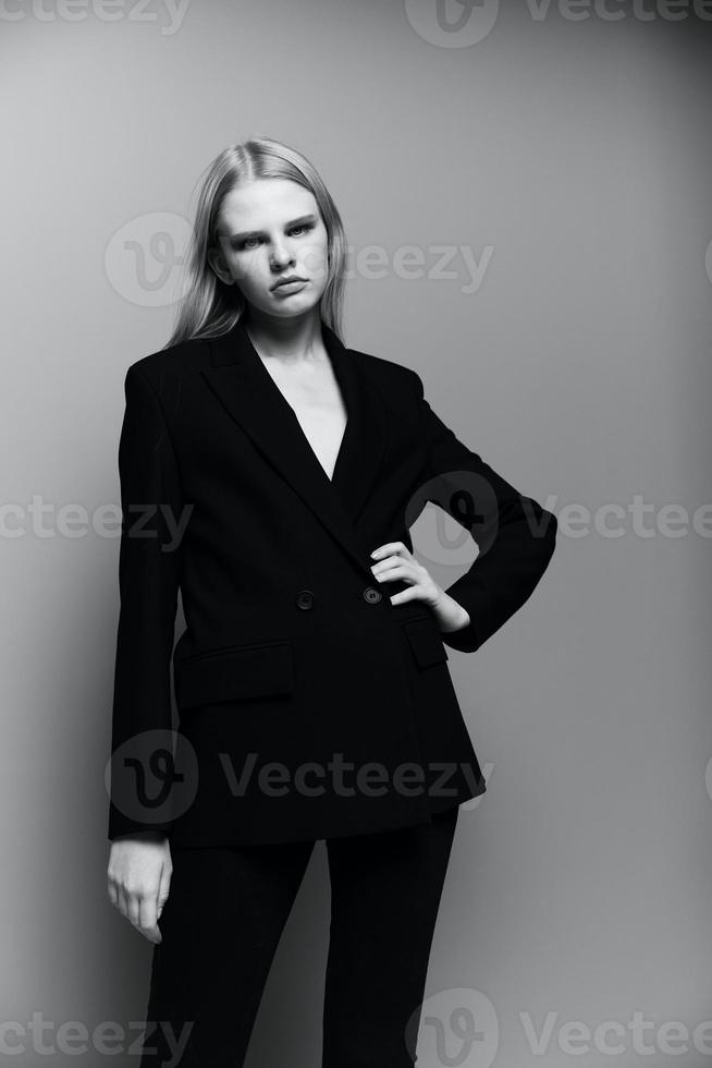 A new collection of brand sales. Blonde in a suit looks at the camera posing in the studio photo