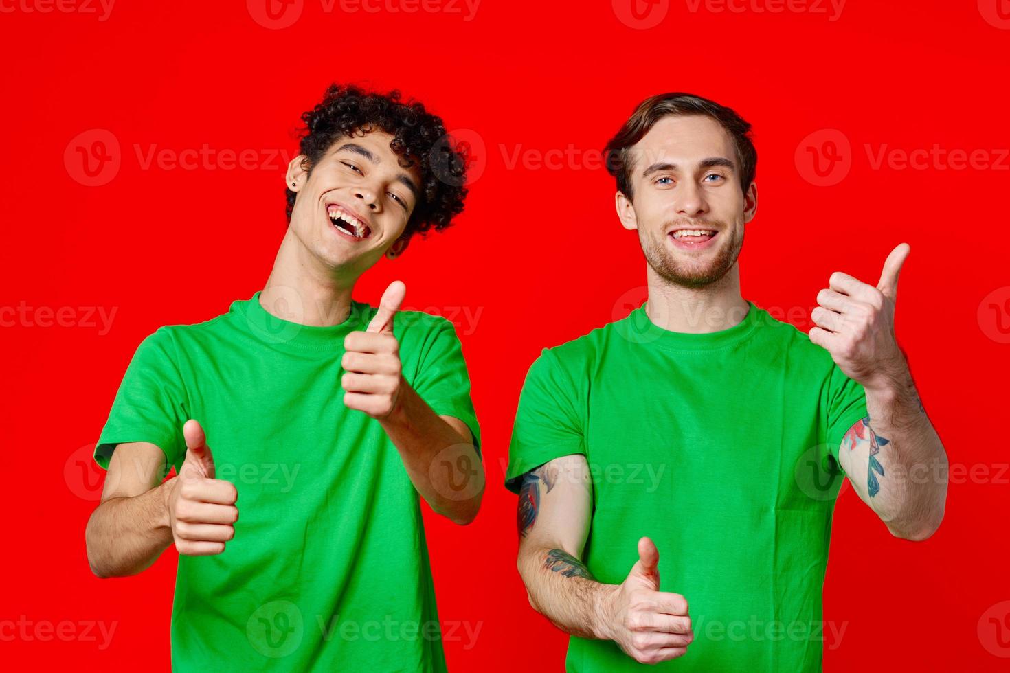 Two cheerful friends from green T-shirts gesticulate with hands emotions photo