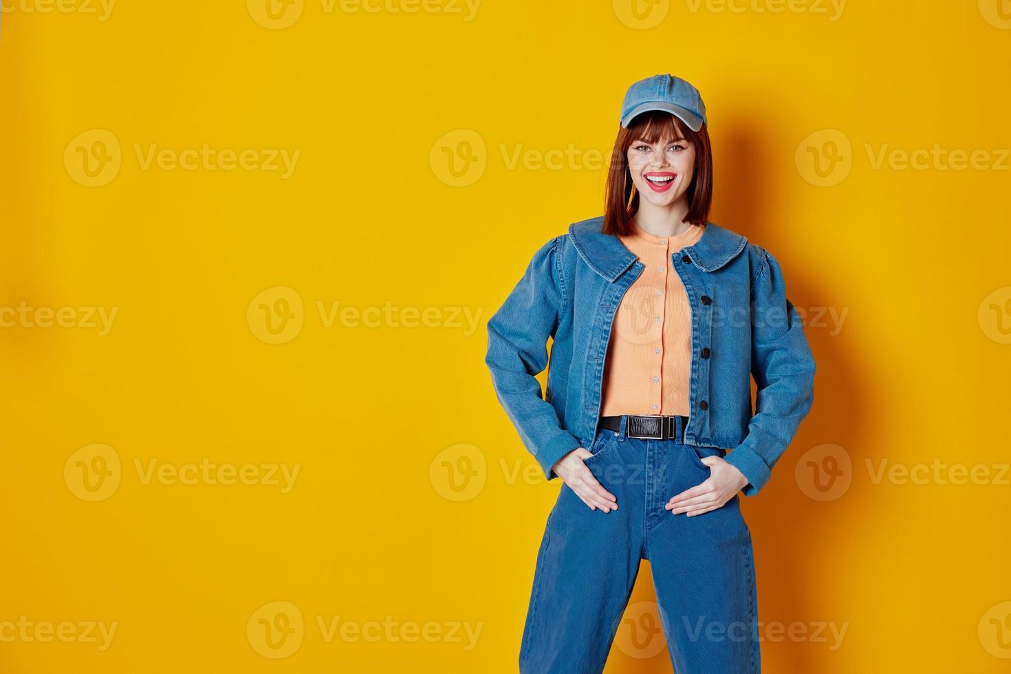Pretty young female in a cap and denim jacket posing color background unaltered photo