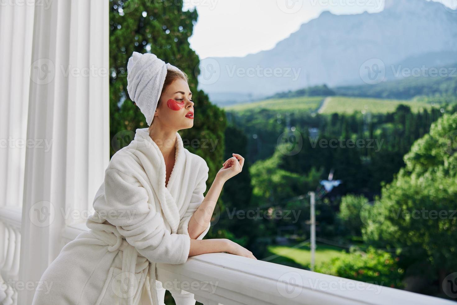 Woman in a bathrobe stands on the balcony of the hotel unaltered photo