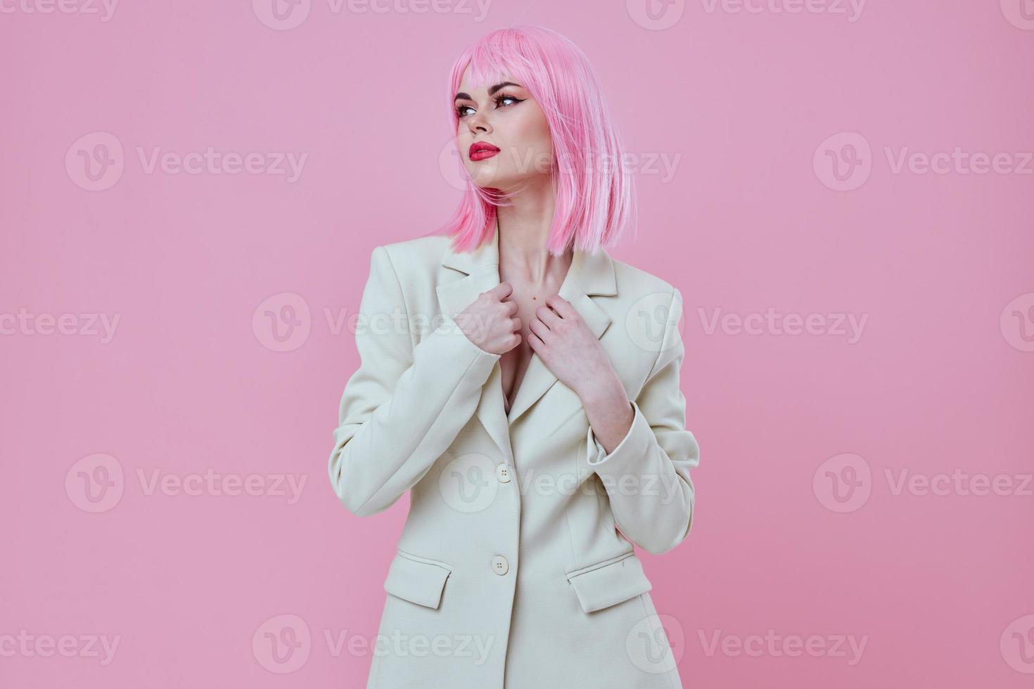 Positive young woman in a suit makeup pink hair posing pink background unaltered photo