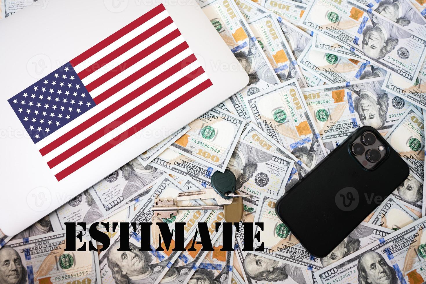 Estimate concept. USA flag, dollar money with keys, laptop and phone background. photo