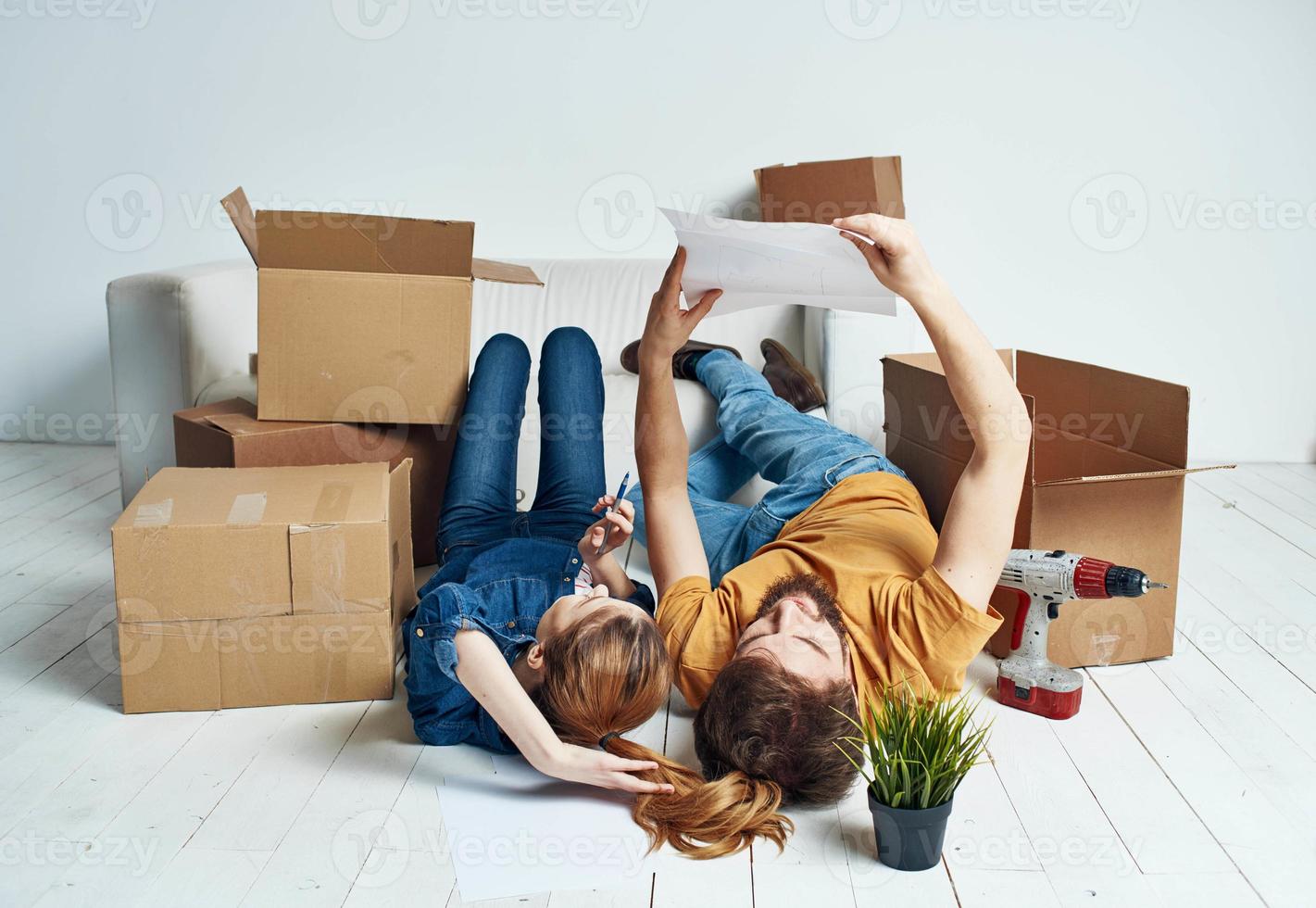 Men and women lie on the floor indoors with boxes of documents of flowers in a pot moving photo