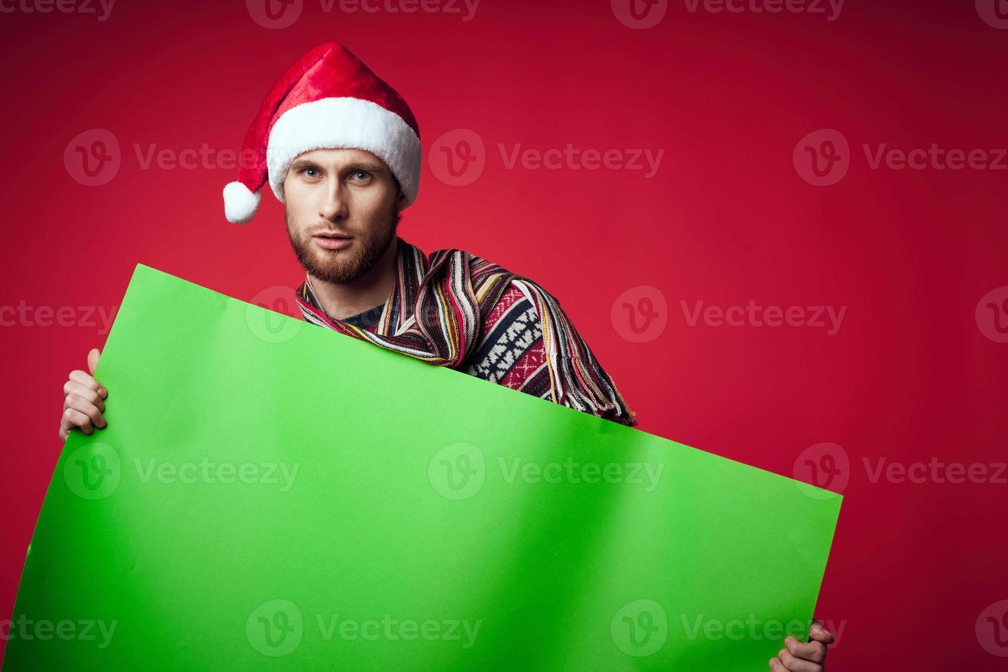 Cheerful man in New Year's clothes advertising copy space red background photo