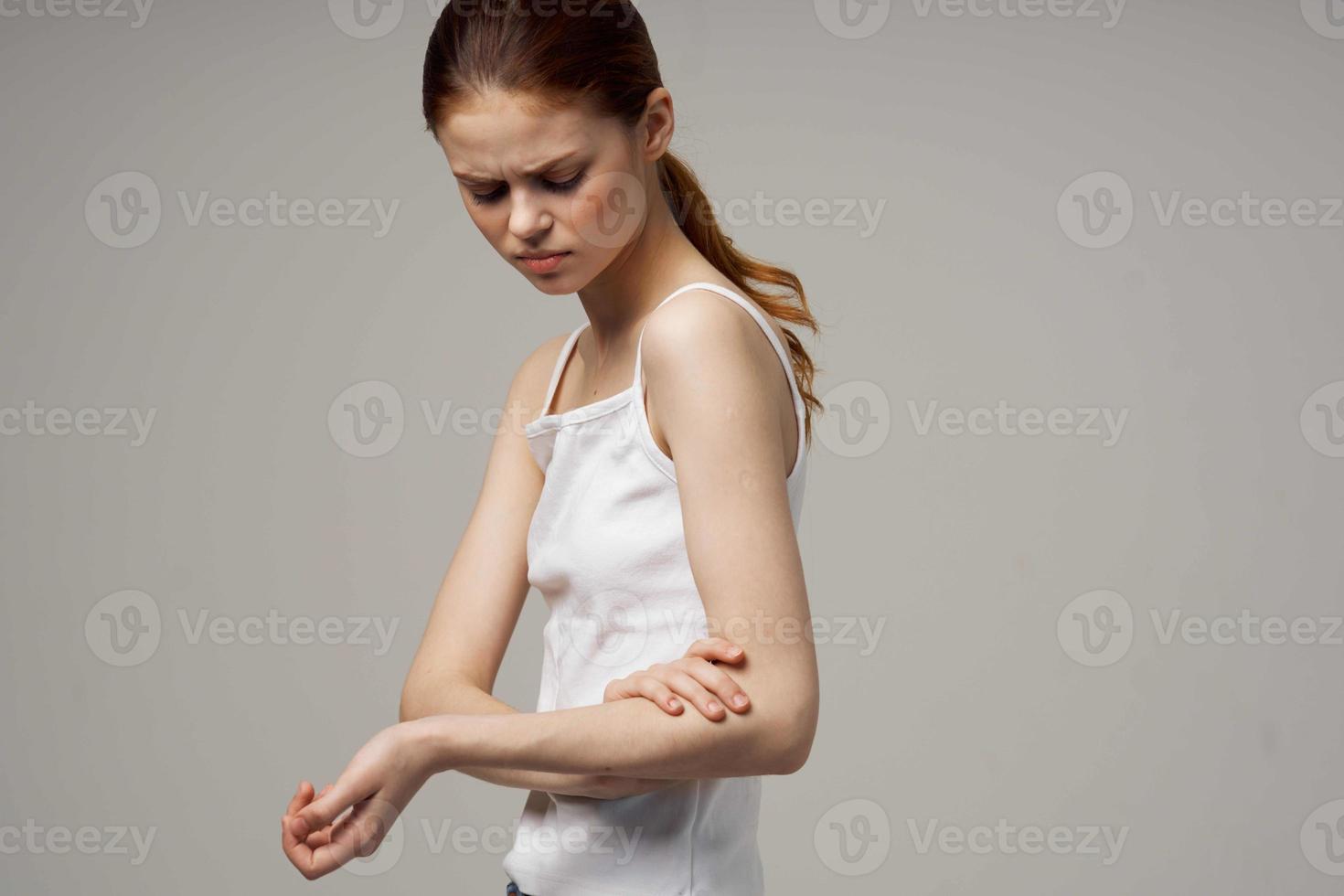 woman in white t-shirt holding on to the elbow health problems joint treatment studio treatment photo
