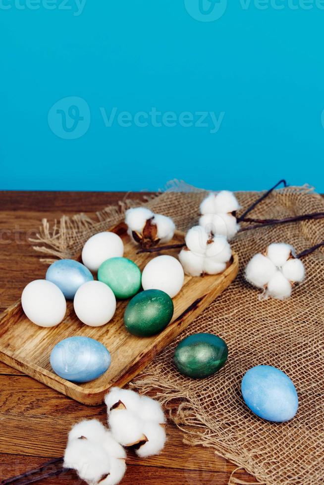 Easter eggs on a wooden board and blue background in the background Copy Space photo