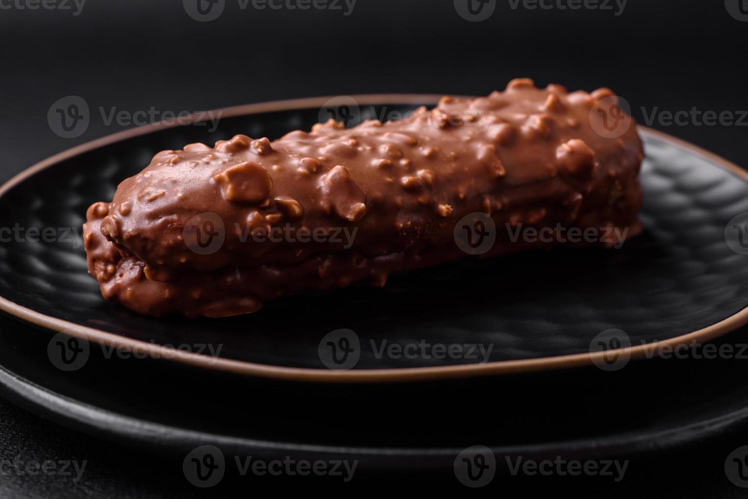 Delicious fresh eclair cake or profiterole with chocolate and nuts photo