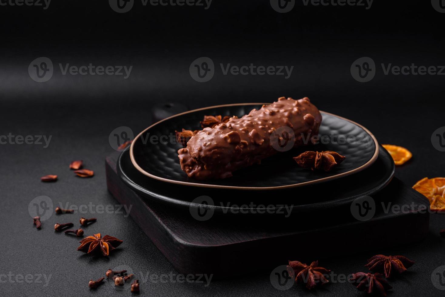 Delicious fresh eclair cake or profiterole with chocolate and nuts photo