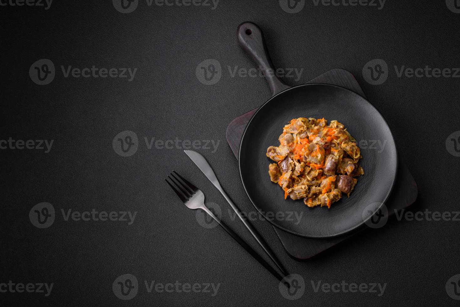Delicious stewed chicken gizzards with carrots and tomato photo