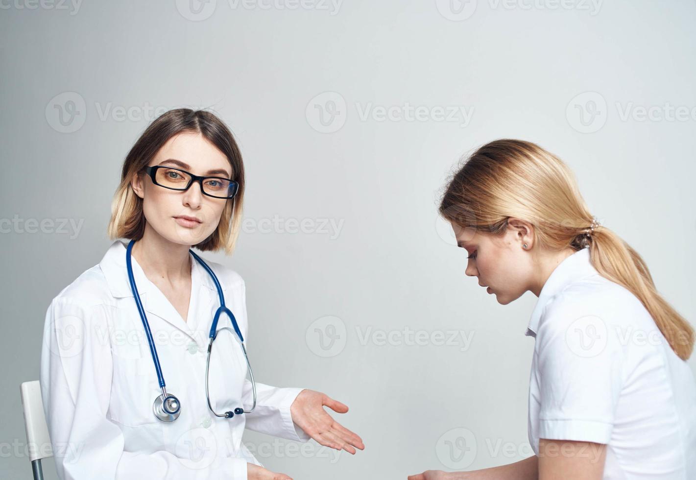 médico se sienta en un silla y mujer paciente adentro en un ligero antecedentes recortado ver foto
