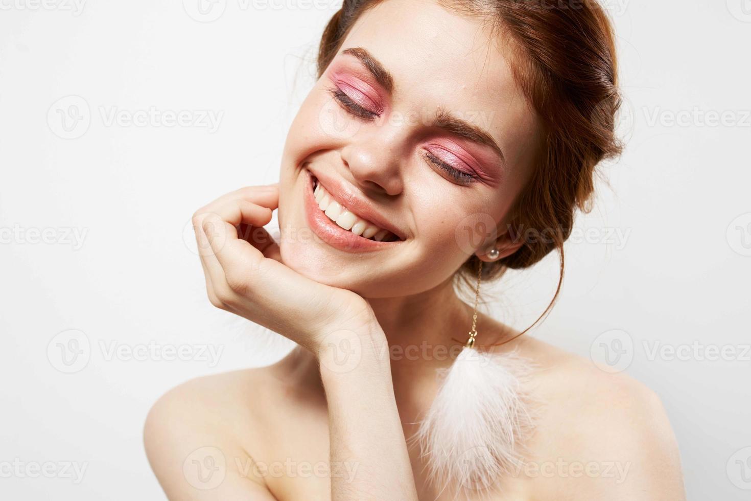 smiling women naked shoulders bright makeup earrings close-up photo