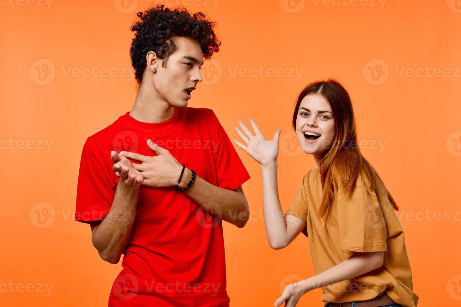 young couple in multicolored t-shirts joy cropped view orange background photo