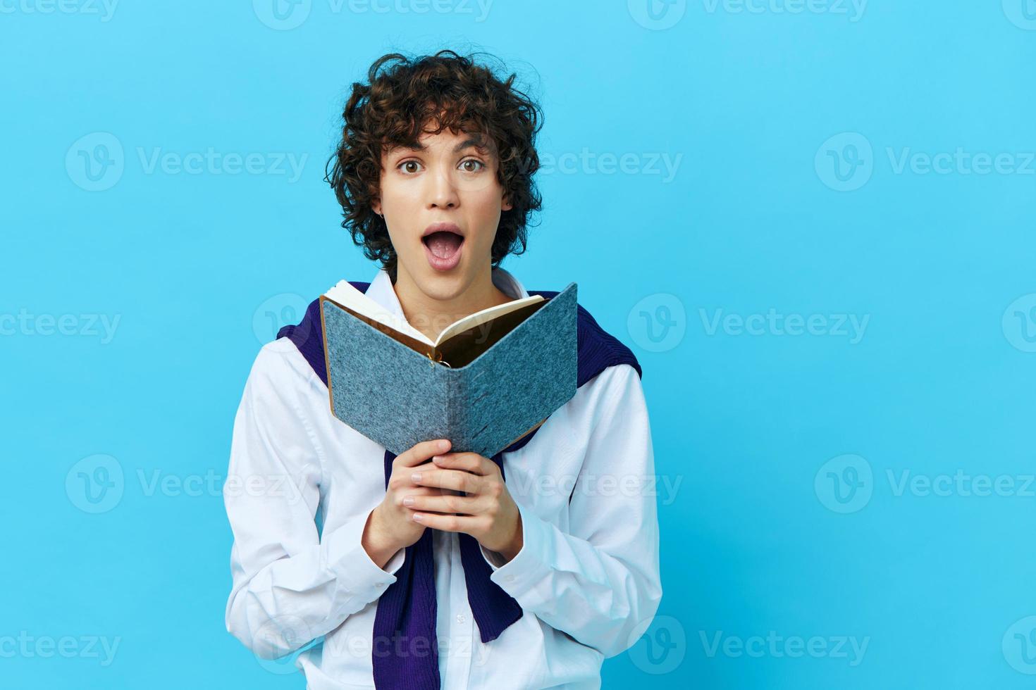 Rizado chico con un libro Universidad aprendizaje chaqueta aislado antecedentes foto