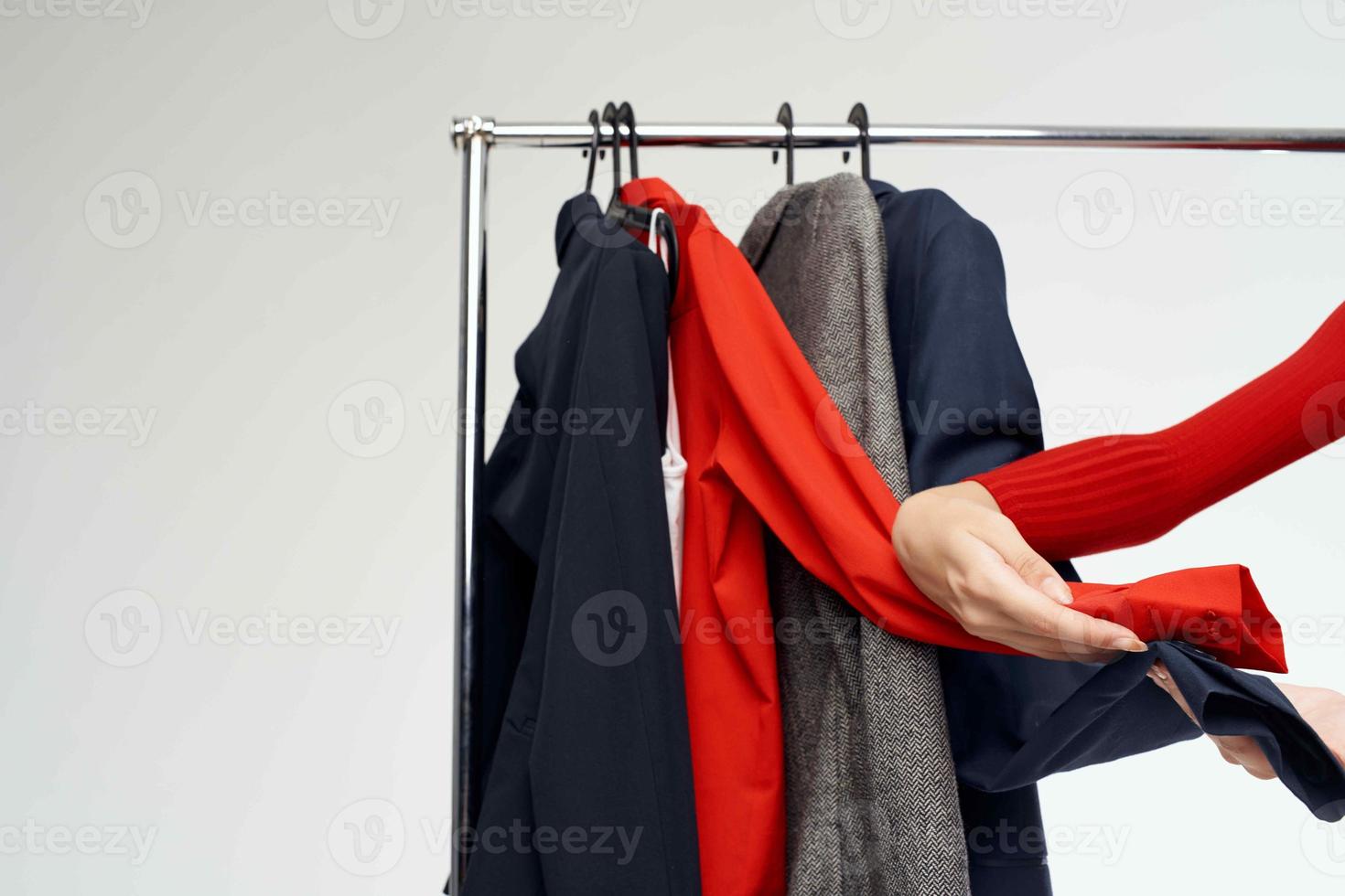 beautiful woman in a red jacket near the wardrobe retail light background photo