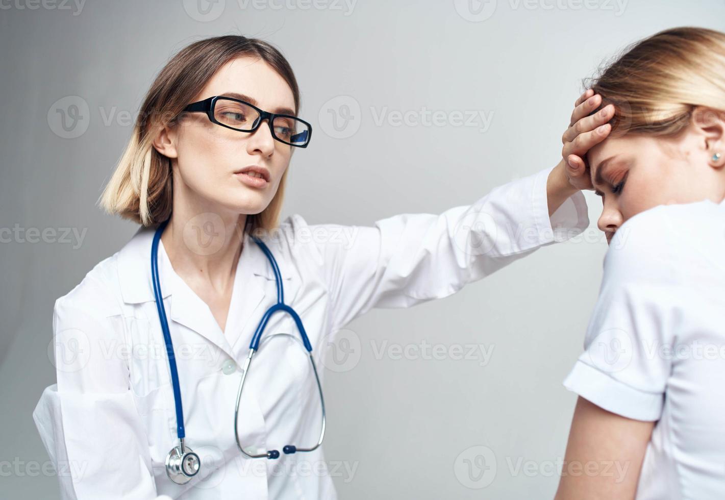 the nurse measures the temperature of the patient and the blue stethoscope photo