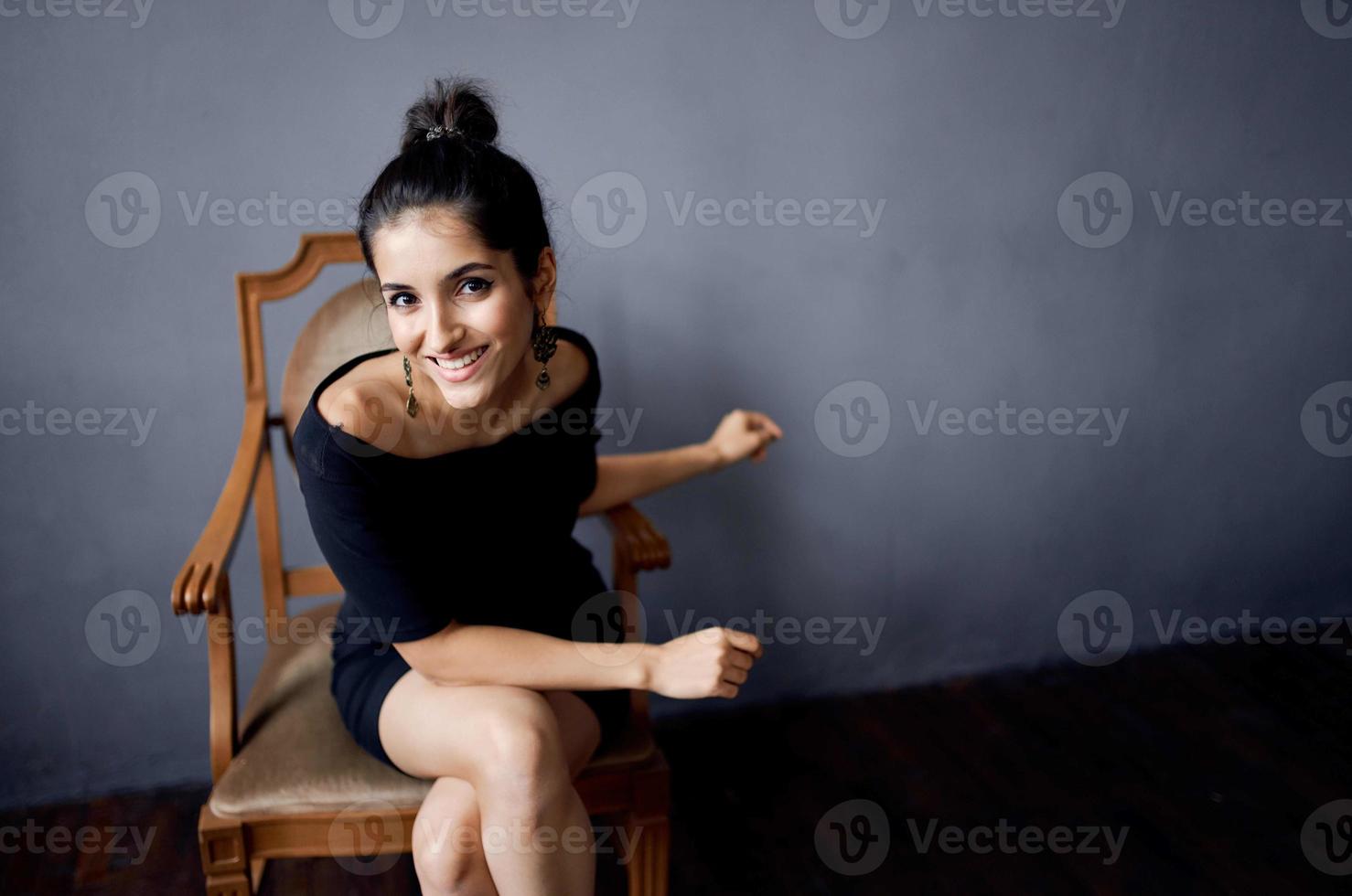 pretty woman in a black dress near the chair luxury fashion isolated background photo