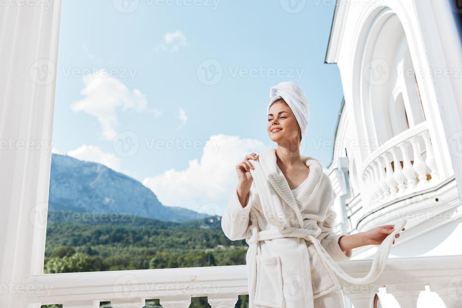 Attractive young woman standing on the balcony looking at the mountains vacation in the mountains in summer unaltered photo