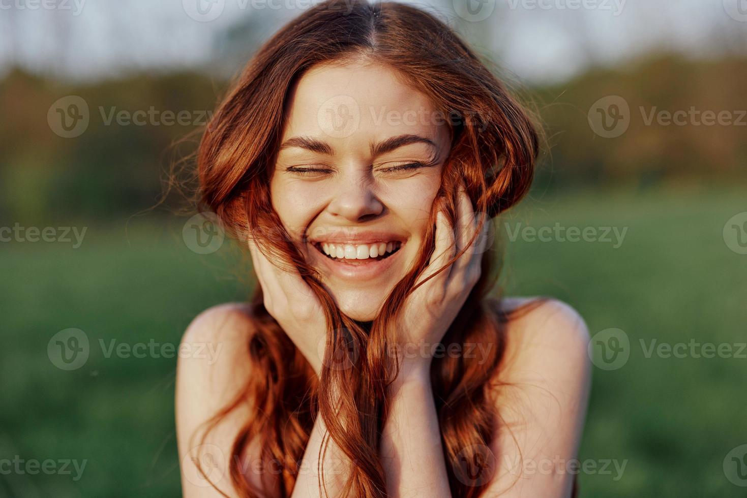 retrato de un joven pelirrojo mujer mirando dentro el cámara y sonriente, de cerca retrato de un riendo mujer en el ajuste luz de sol foto