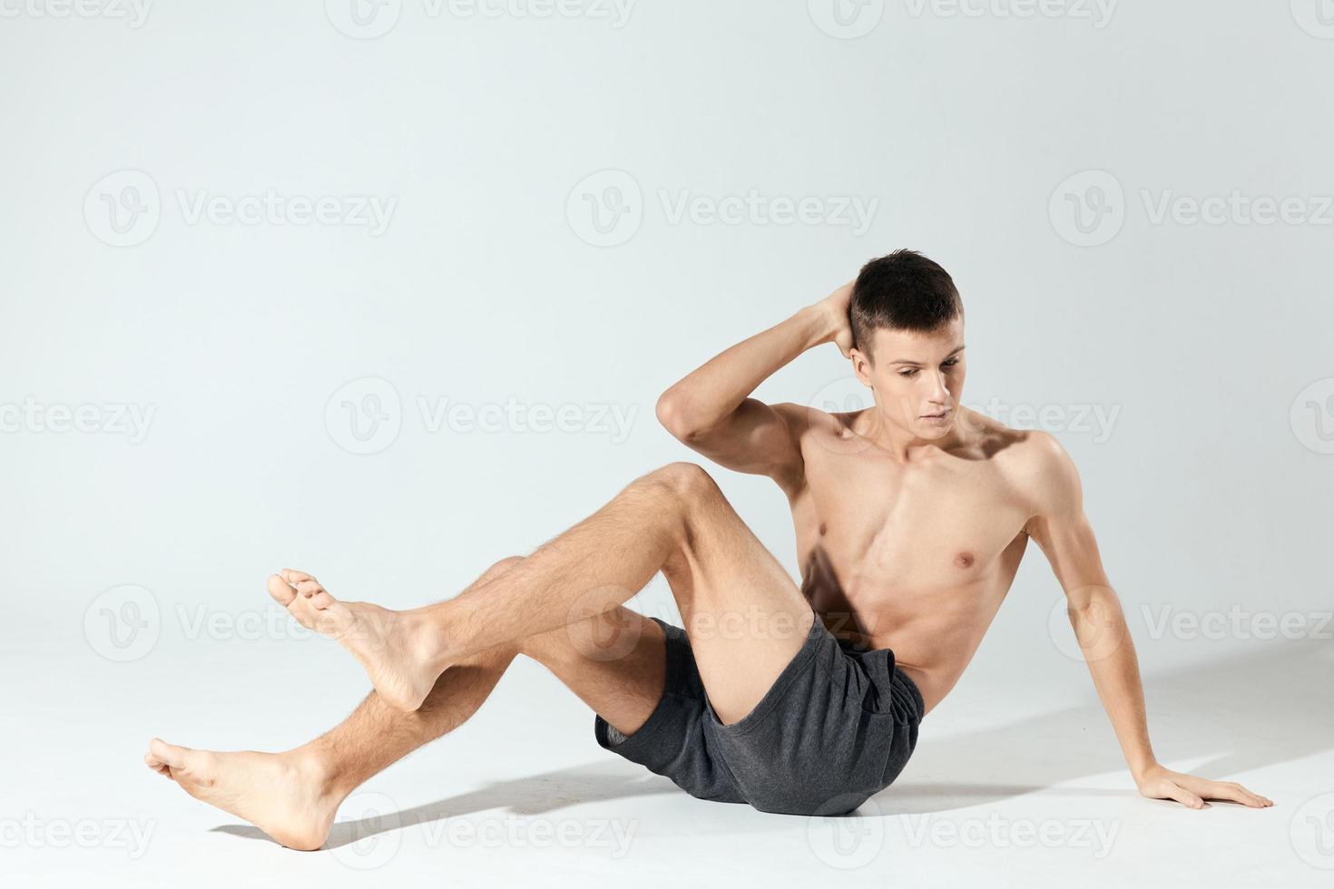 morning exercises young athlete in gray shorts and an inflated torso fitness workout photo