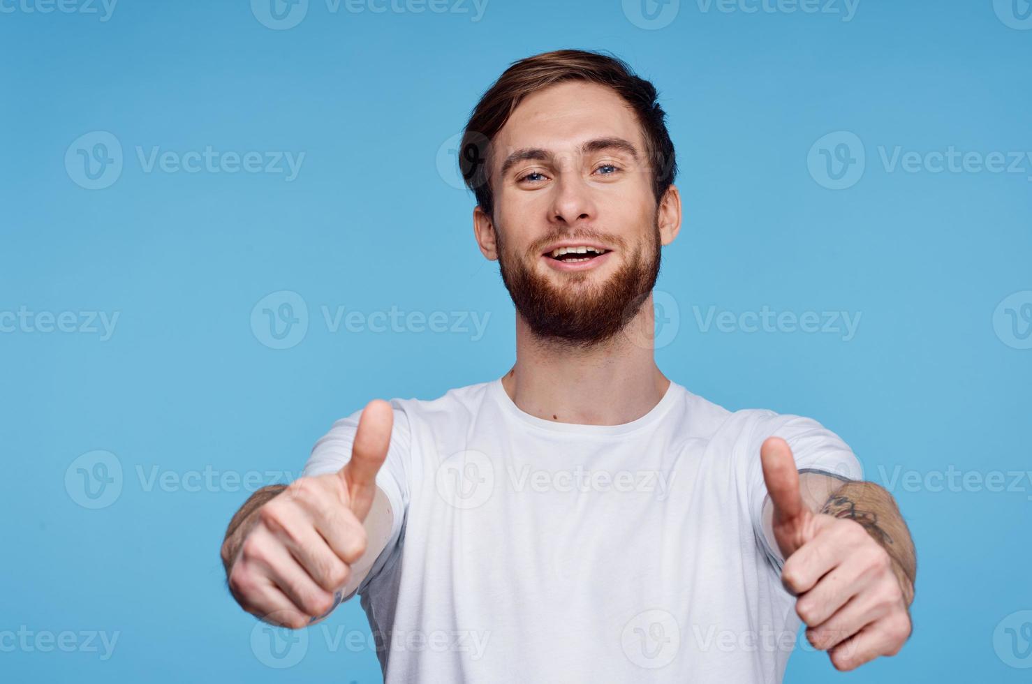 Cheerful man in a white t-shirt gesturing with his hands fashion modern style photo